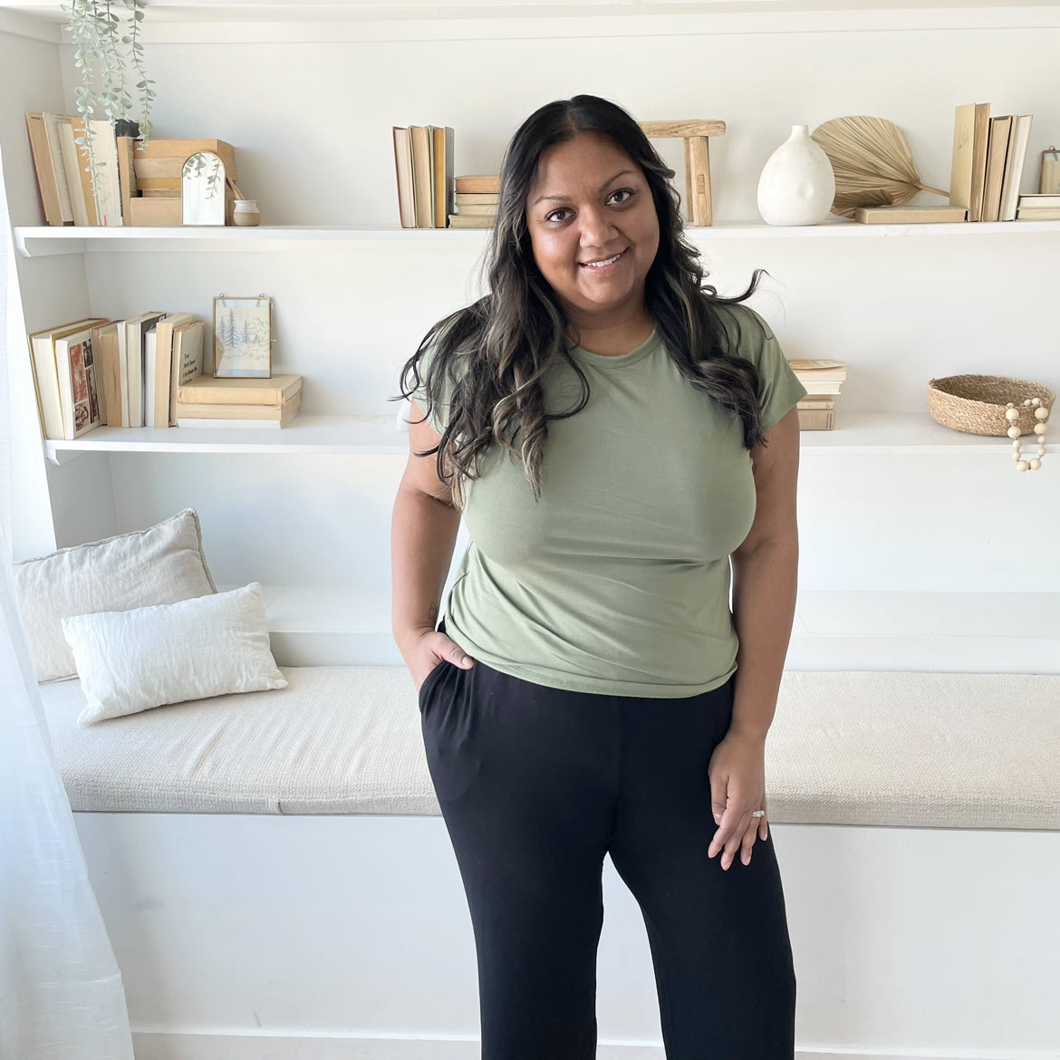 indian woman standing in a sage green t shirt and black wide leg pants