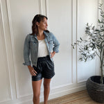 woman wearing square neck tank top and vegan leather paper bag shorts  and denim jacket