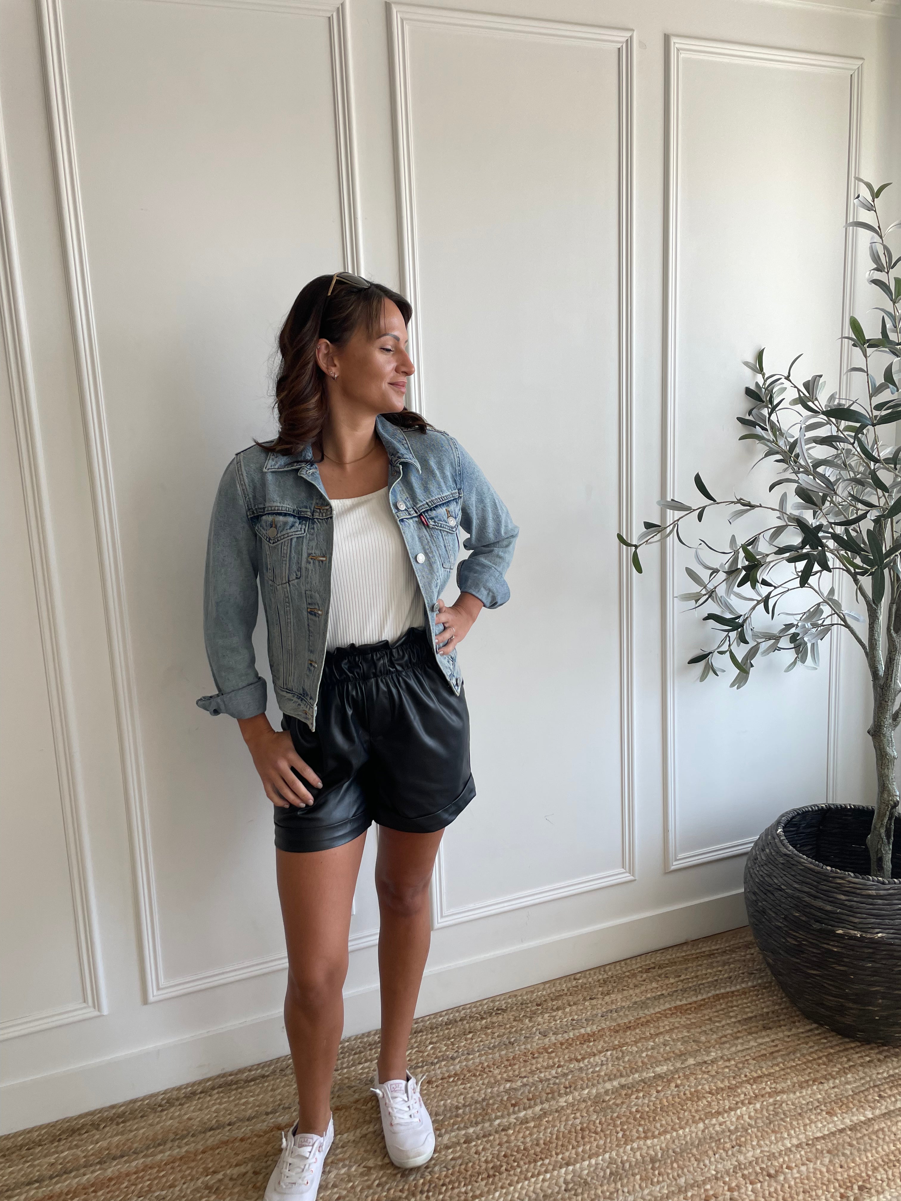 woman wearing square neck tank top and vegan leather paper bag shorts  and denim jacket