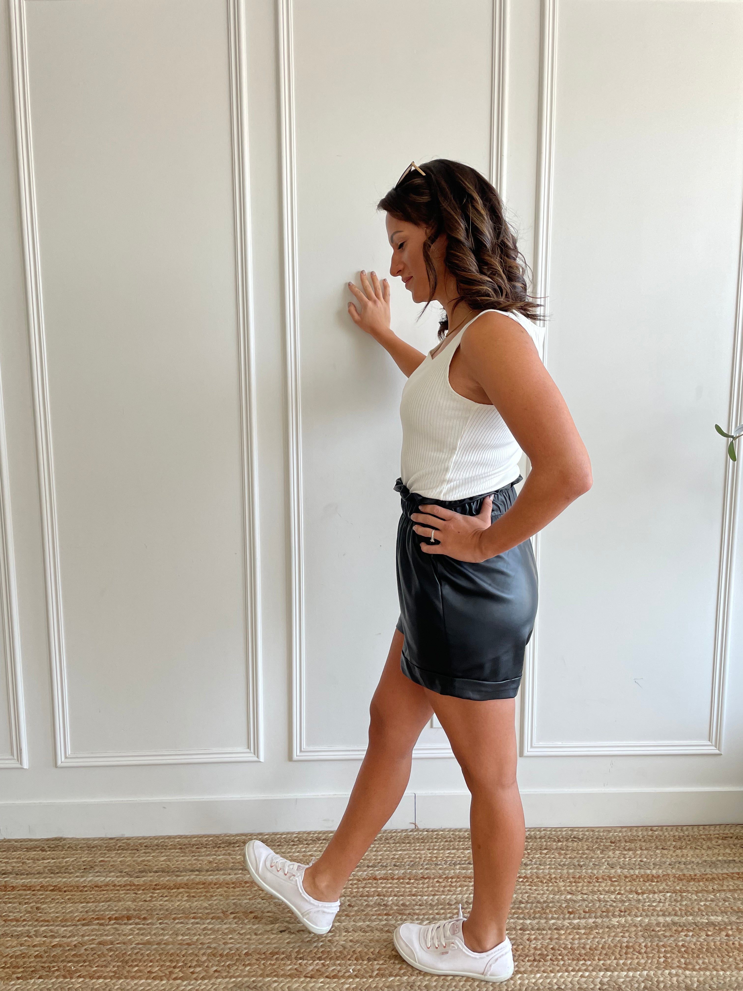woman wearing square neck tank top and vegan leather paper bag shorts 