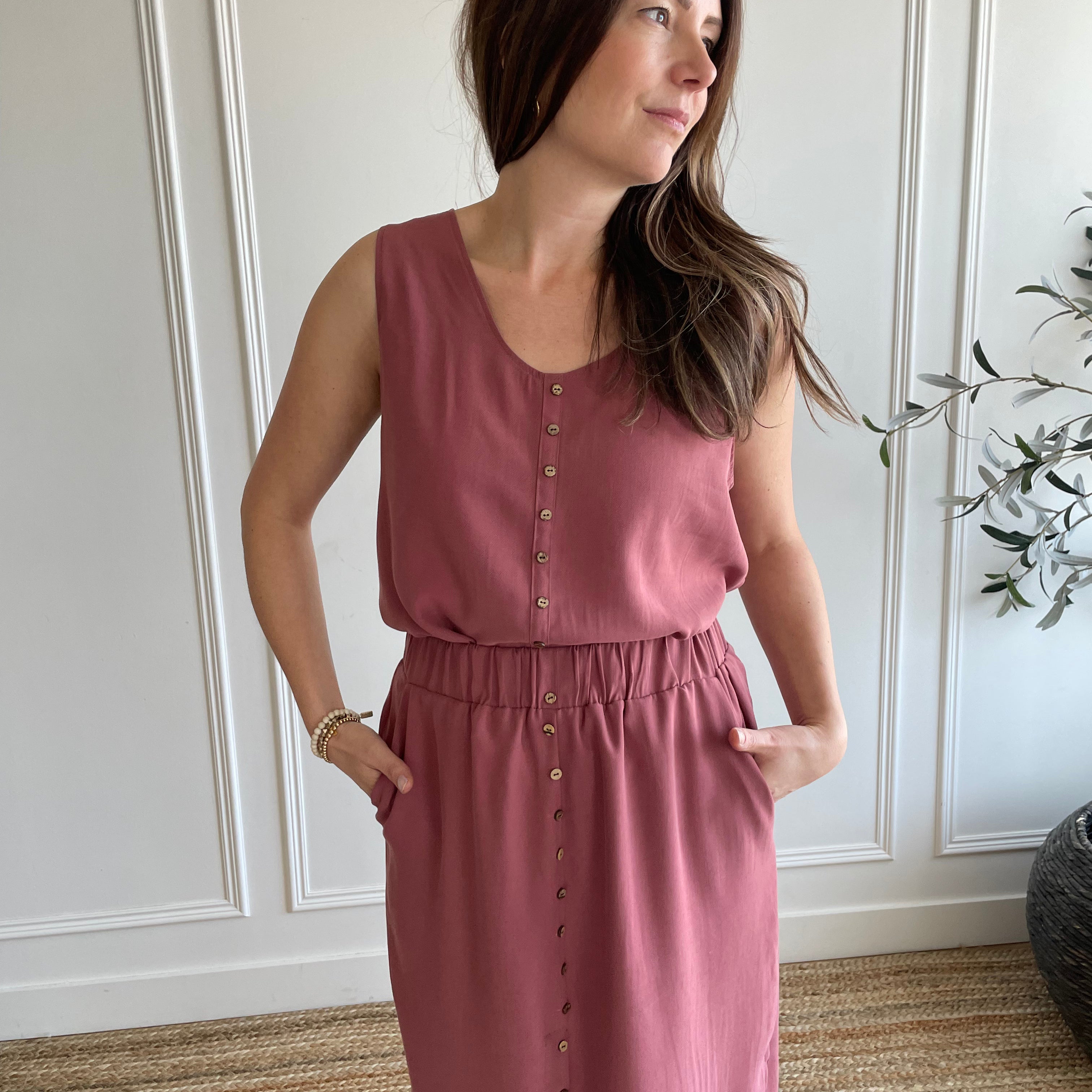 pink loose fitting women's tank top with brown buttons and pink flowy midi skirt with side slits 