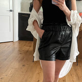 woman wearing square neck tank top and vegan leather paper bag shorts 