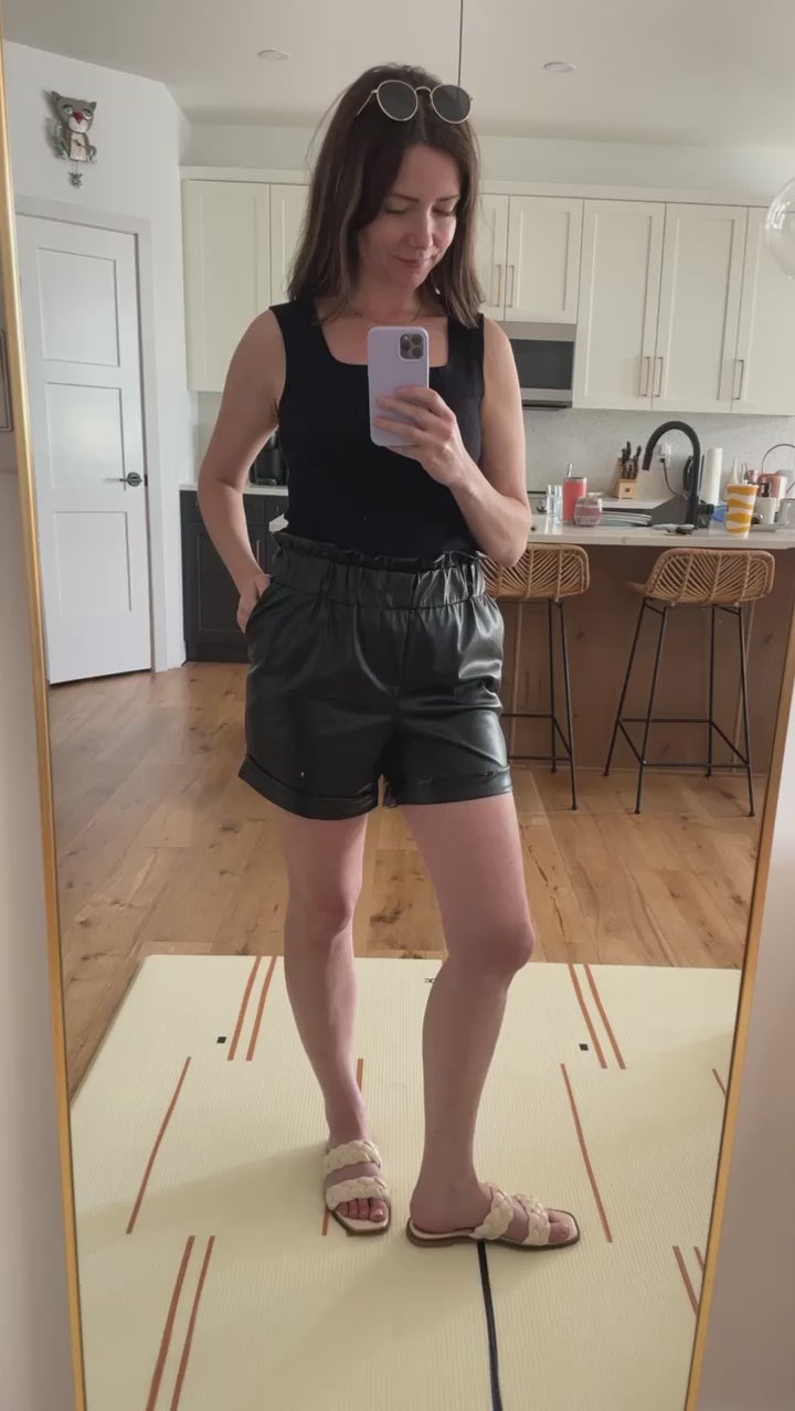 video of a woman wearing black vegan leather shorts
