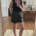 video of a woman wearing black vegan leather shorts