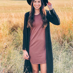 woman wearing black hat, black long cardigan and brown dress