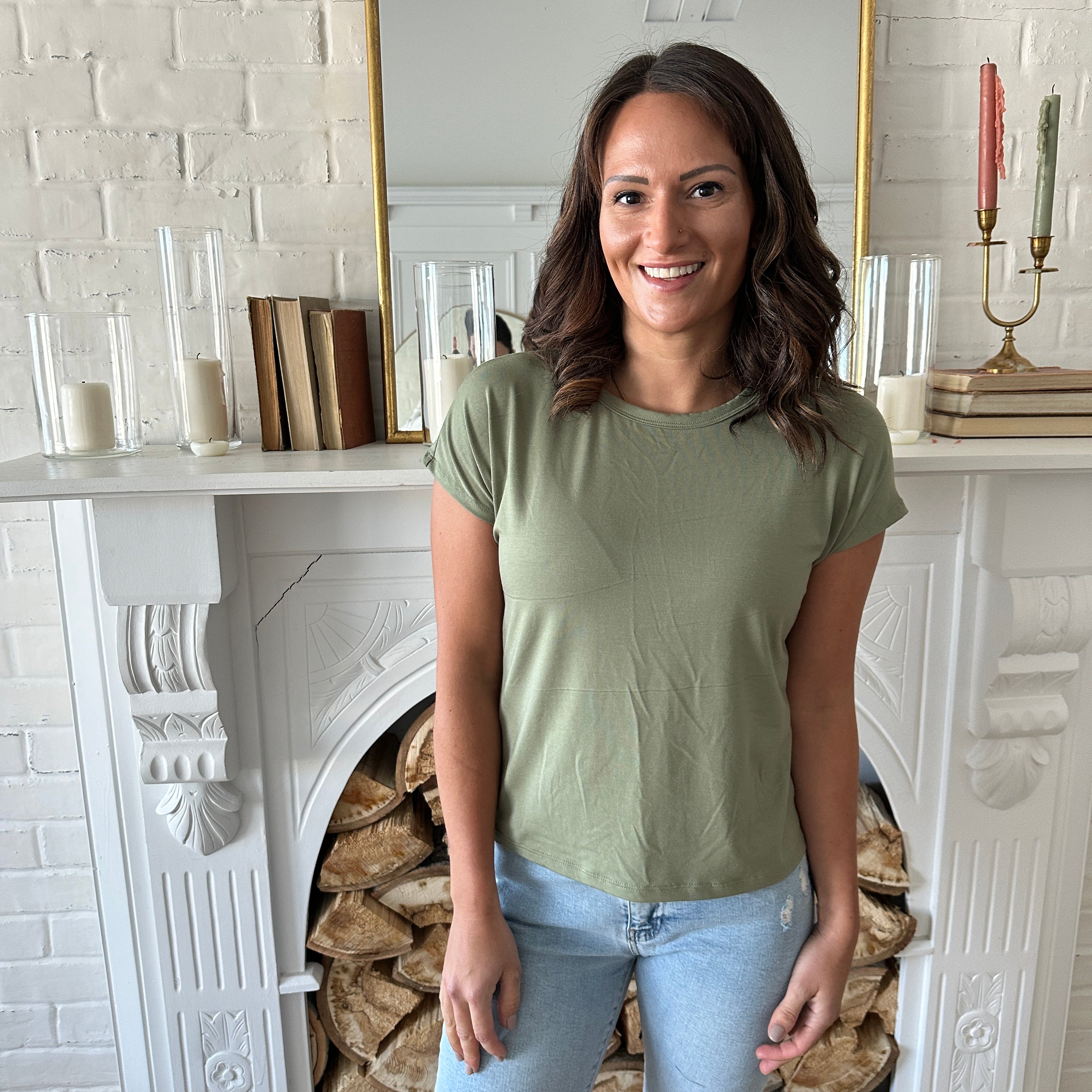 Woman wearing a sage green bamboo t-shirt and jeans