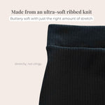 Close-up of black ribbed knit fabric with text describing its softness and stretchiness.