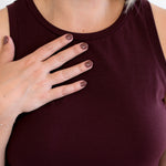 Person wearing a maroon tank dress made in canada with a plain background