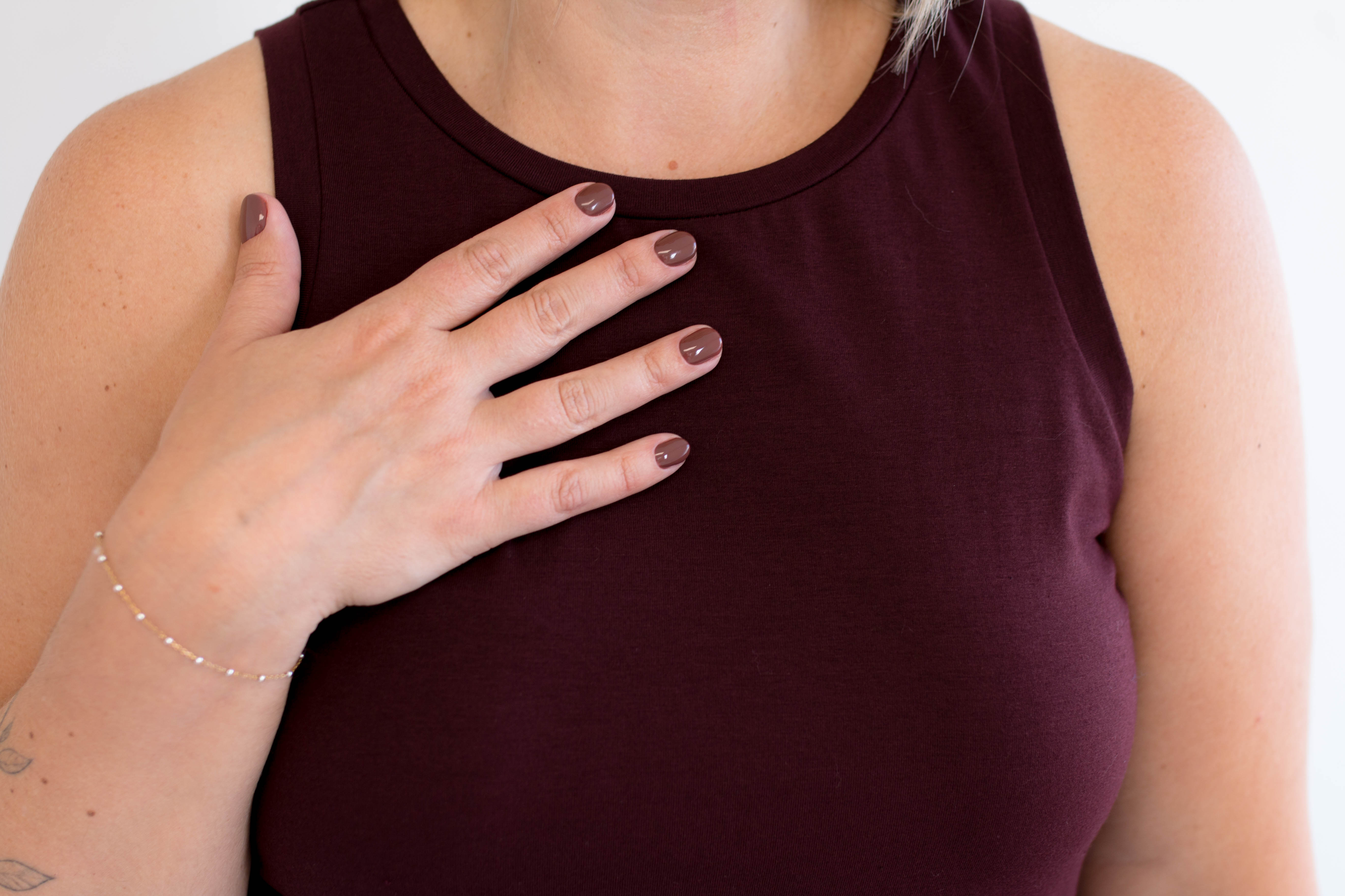 Person wearing a maroon tank dress made in canada with a plain background