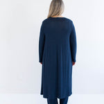 Woman wearing a long navy cardigan made in canada on a white background