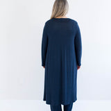 Woman wearing a long navy cardigan made in canada on a white background