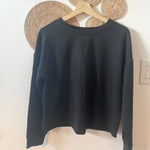 Black bamboo sweatshirt hanging on hanger