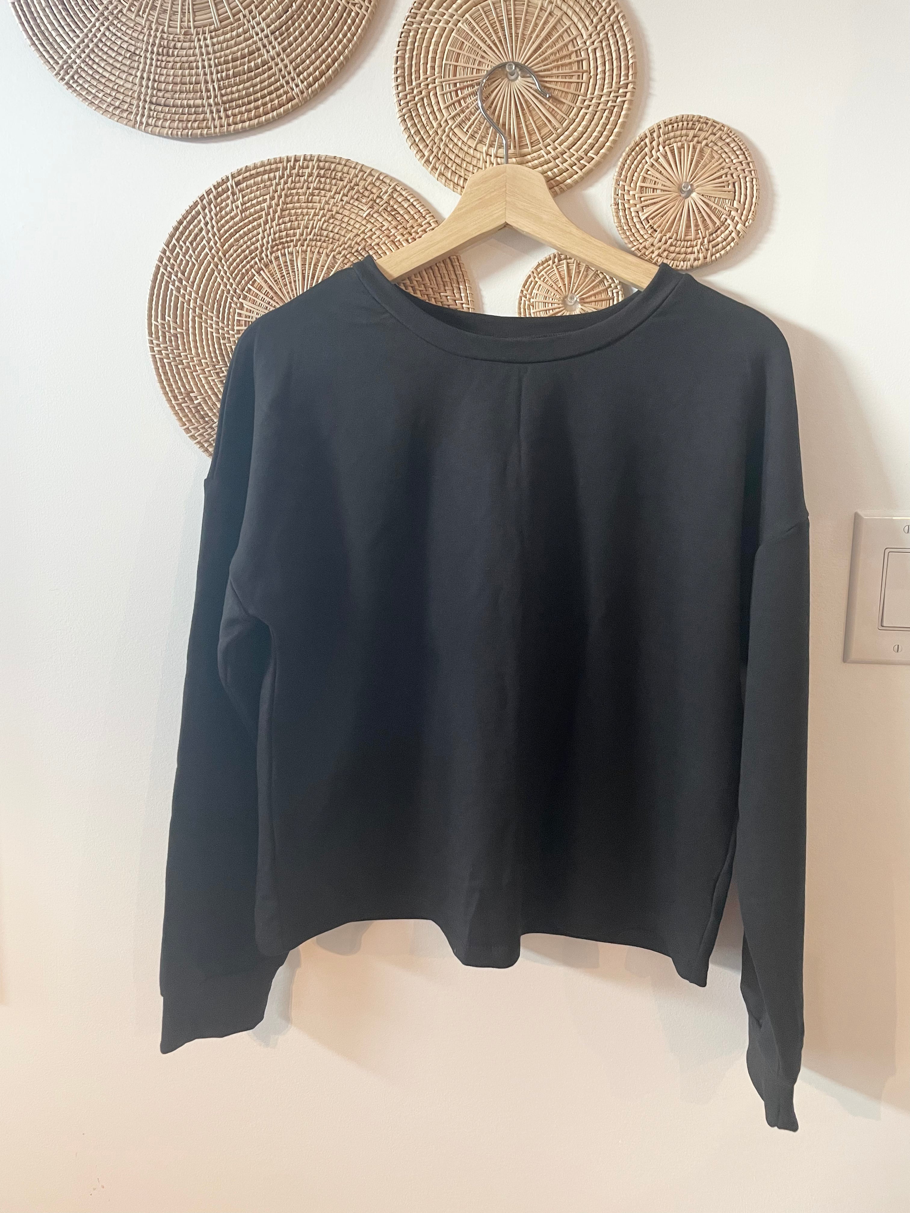 Black bamboo sweatshirt hanging on hanger