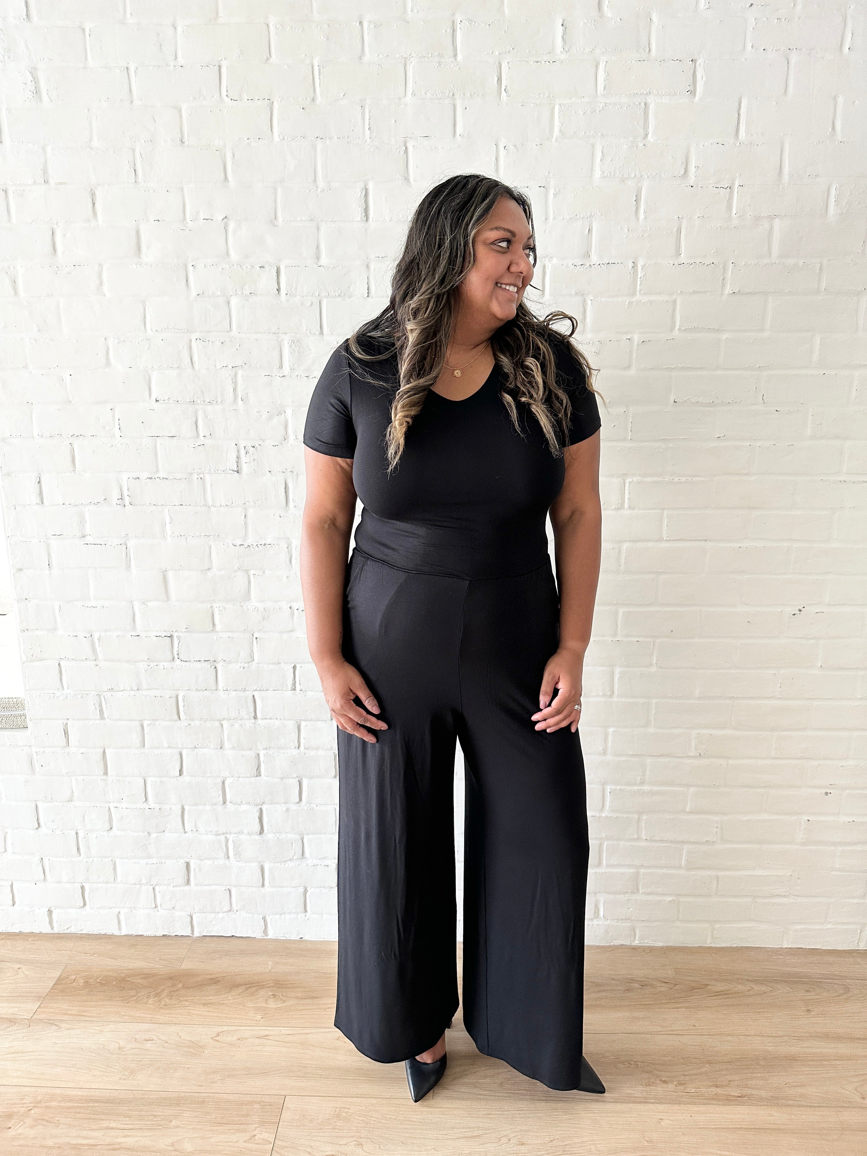 woman wearing black romper with wide leg pants and pockets
