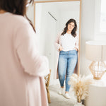 woman wearing long pink cardigan and white t-shirt and jeans