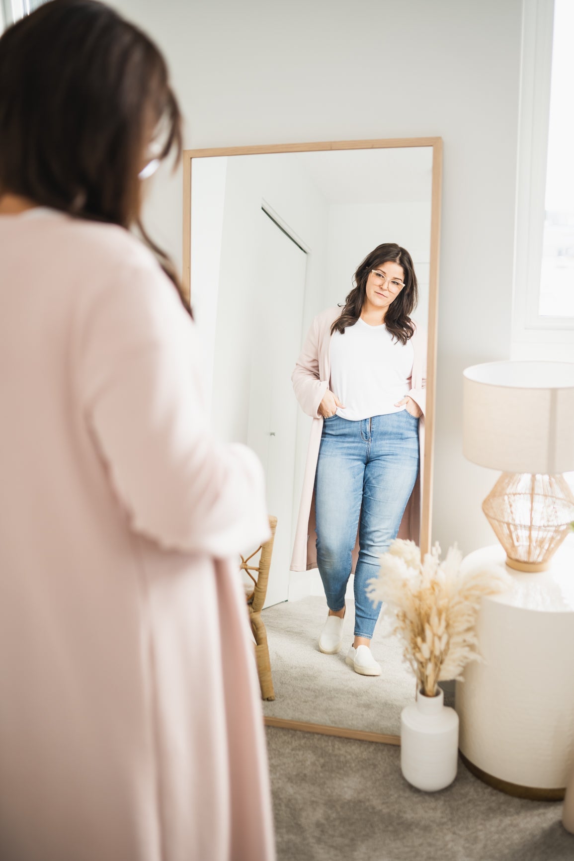 woman wearing long pink cardigan and white t-shirt and jeans