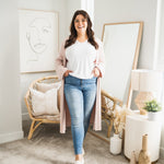 woman wearing long pink cardigan and white t-shirt and jeans