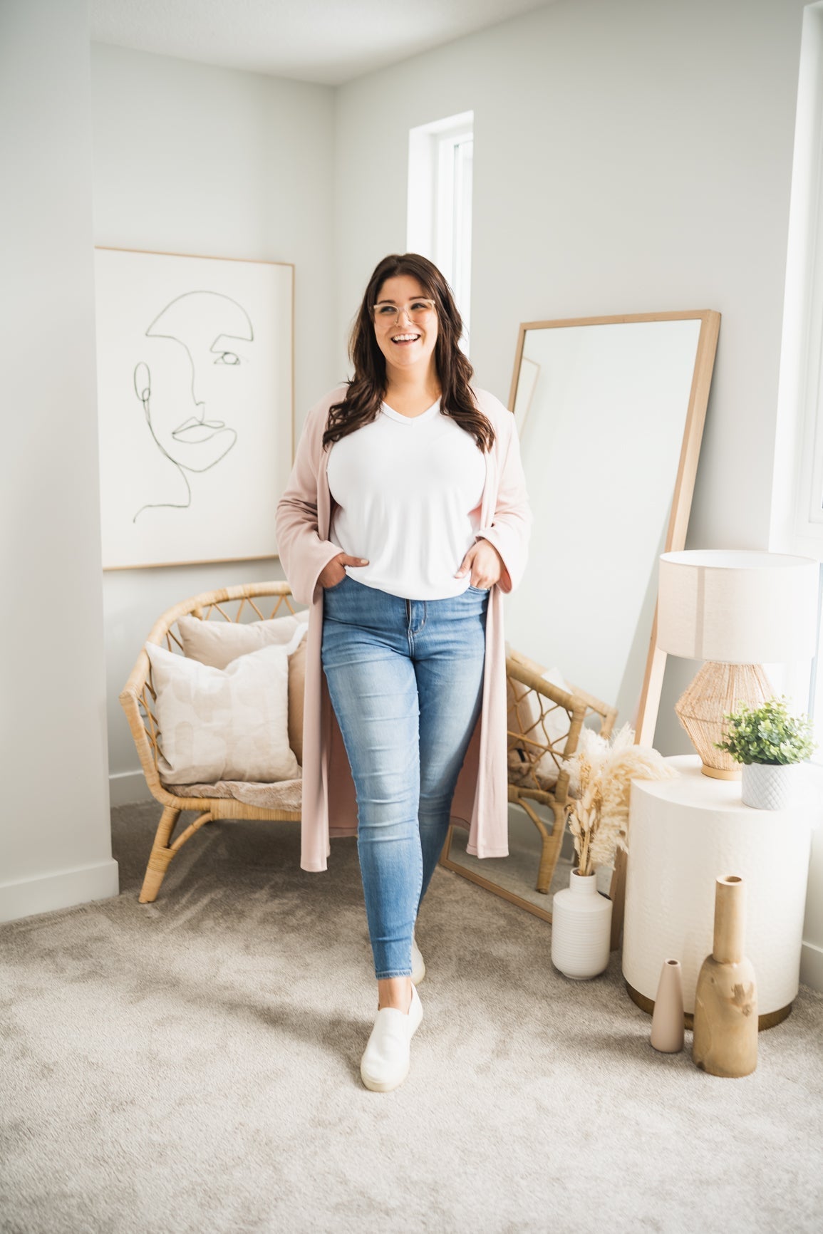 woman wearing long pink cardigan and white t-shirt and jeans