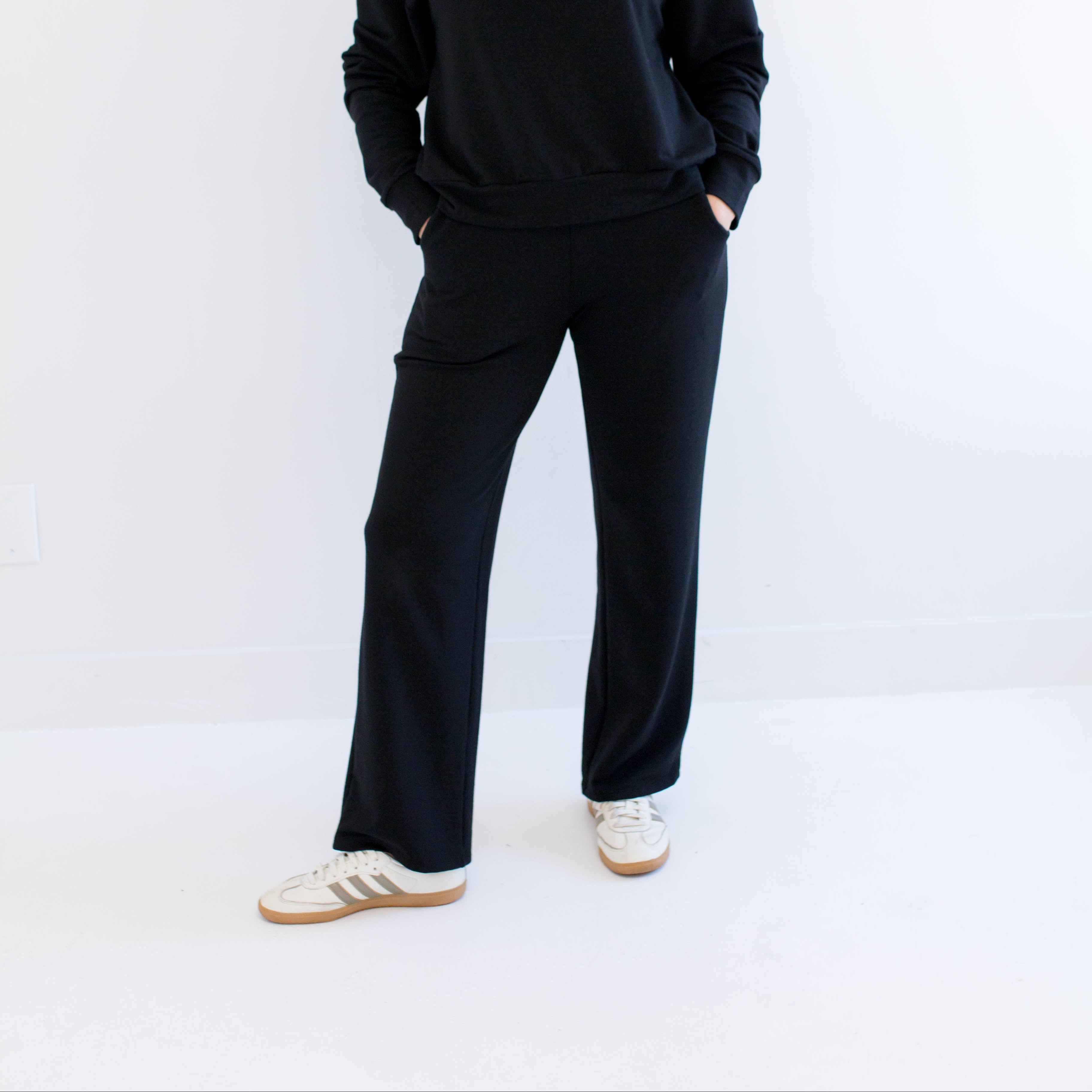 Woman wearing a black wide leg pants on a white background. Apparel made in canada