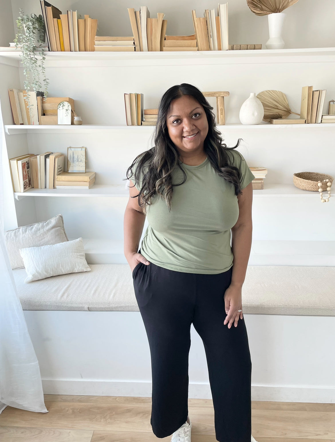 indian woman standing in a sage green t shirt and black wide leg pants