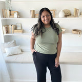 indian woman standing in a sage green t shirt and black wide leg pants