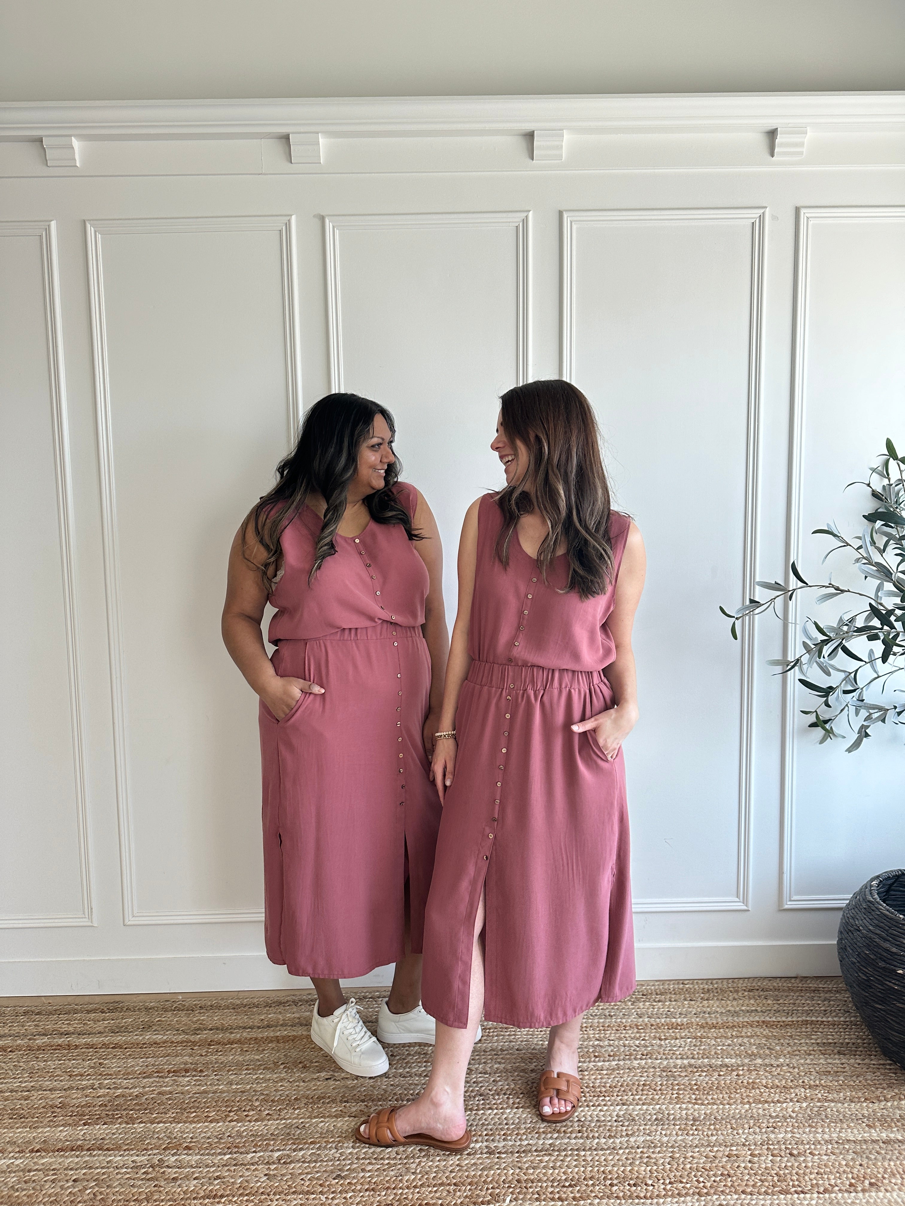 pink loose fitting tank top with brown buttons and pink loose fitting midi skirt with side slits with brown buttons on models standing wearing neutral sandals