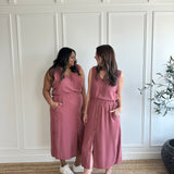 pink loose fitting tank top with brown buttons and pink loose fitting midi skirt with side slits with brown buttons on models standing wearing neutral sandals