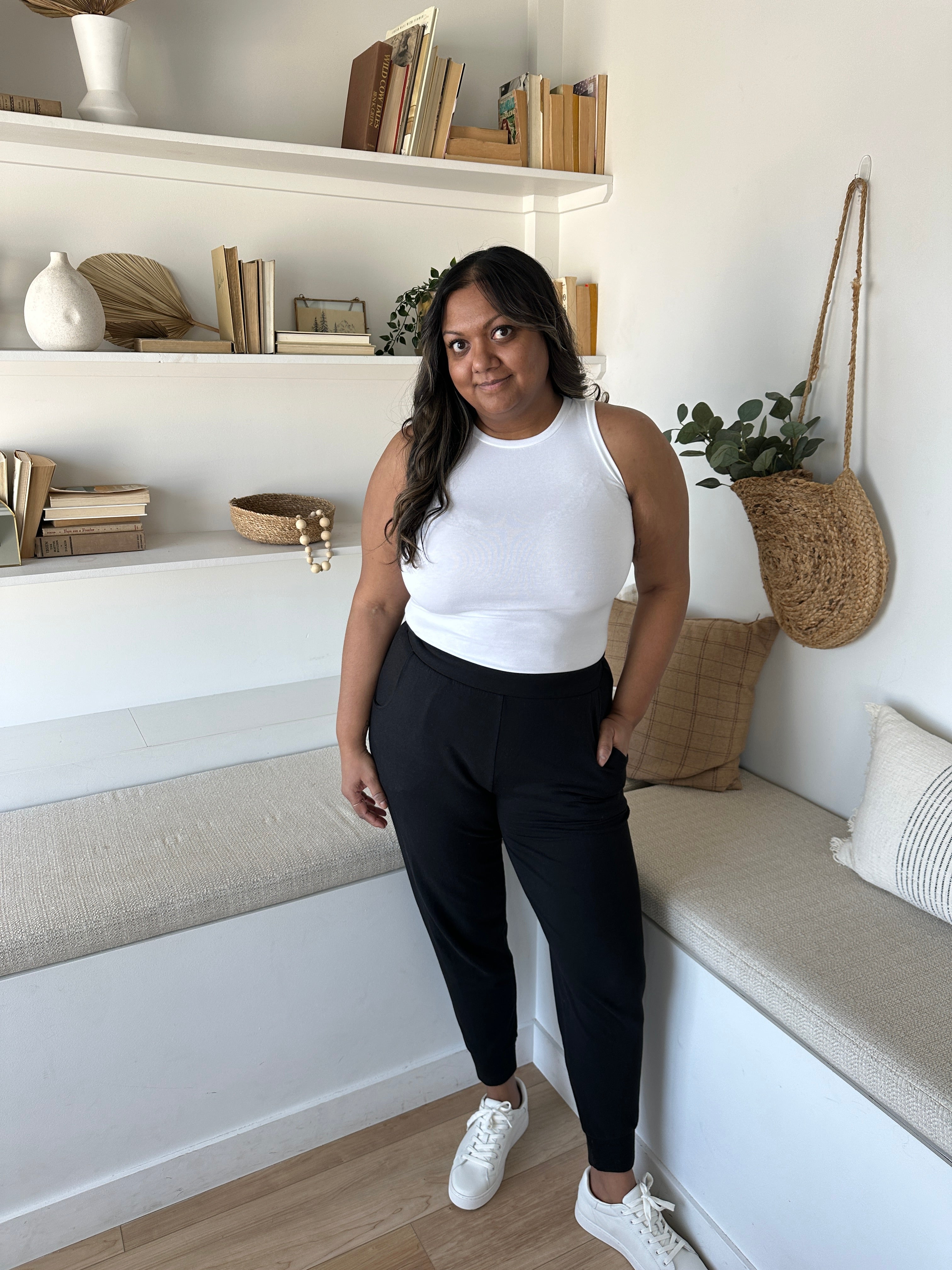 woman wearing white high neck tank and black joggers