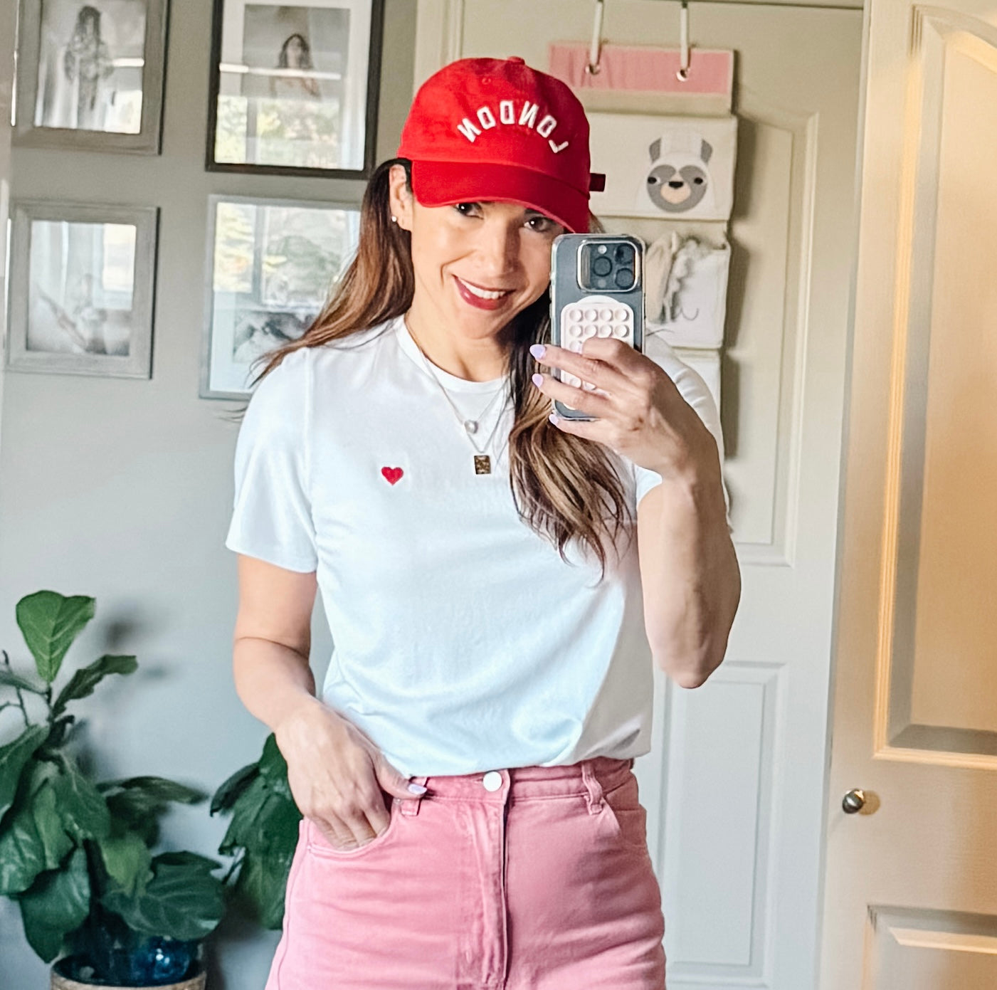 Model wearing Made in Canada with Love Heart T-shirt Ang Hill with pink pants and red cap close up