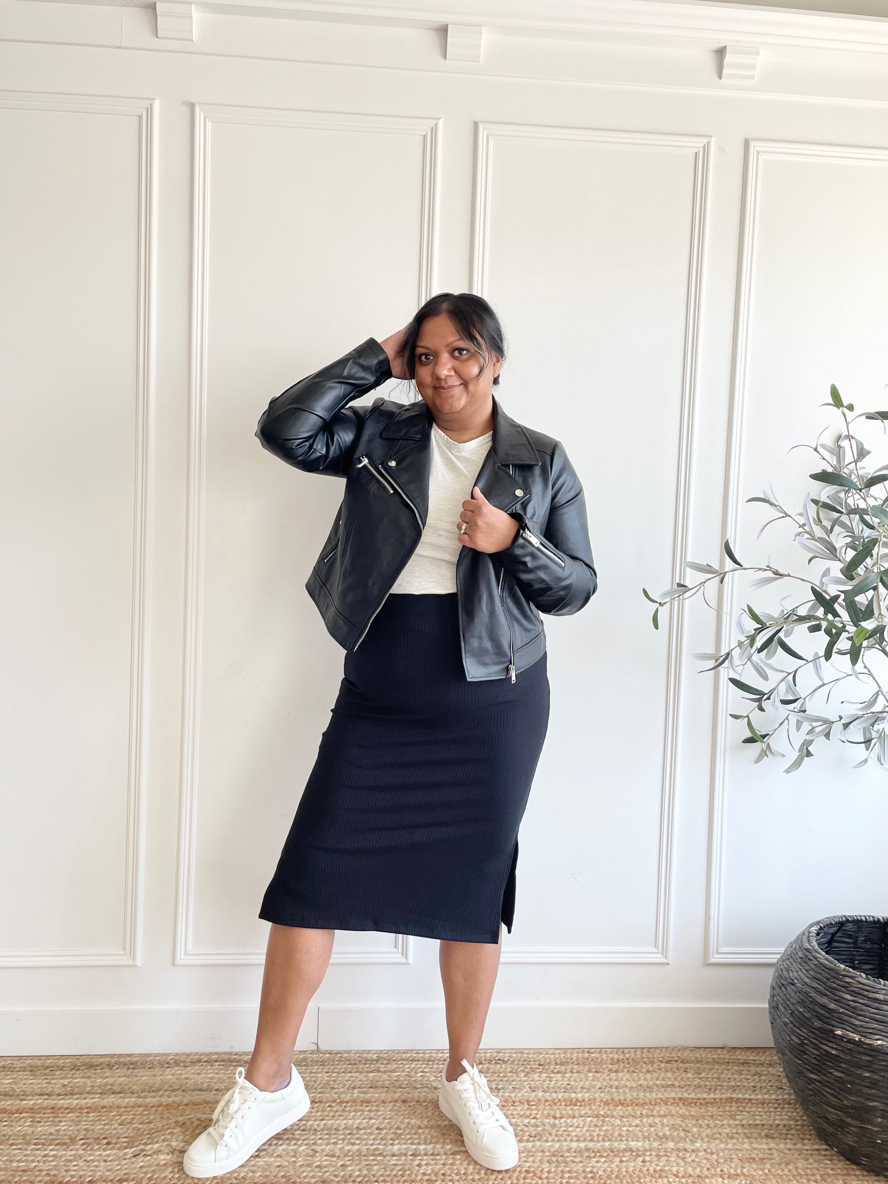 woman wearing black moto jacket, black midi skirt and crewneck t-shirt