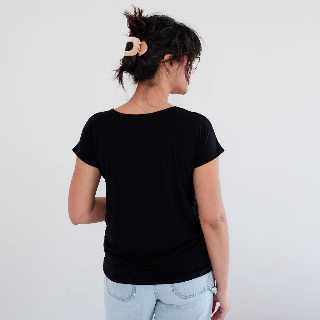 Person wearing a black t-shirt and light blue jeans against a white background. Apparel made in Canada