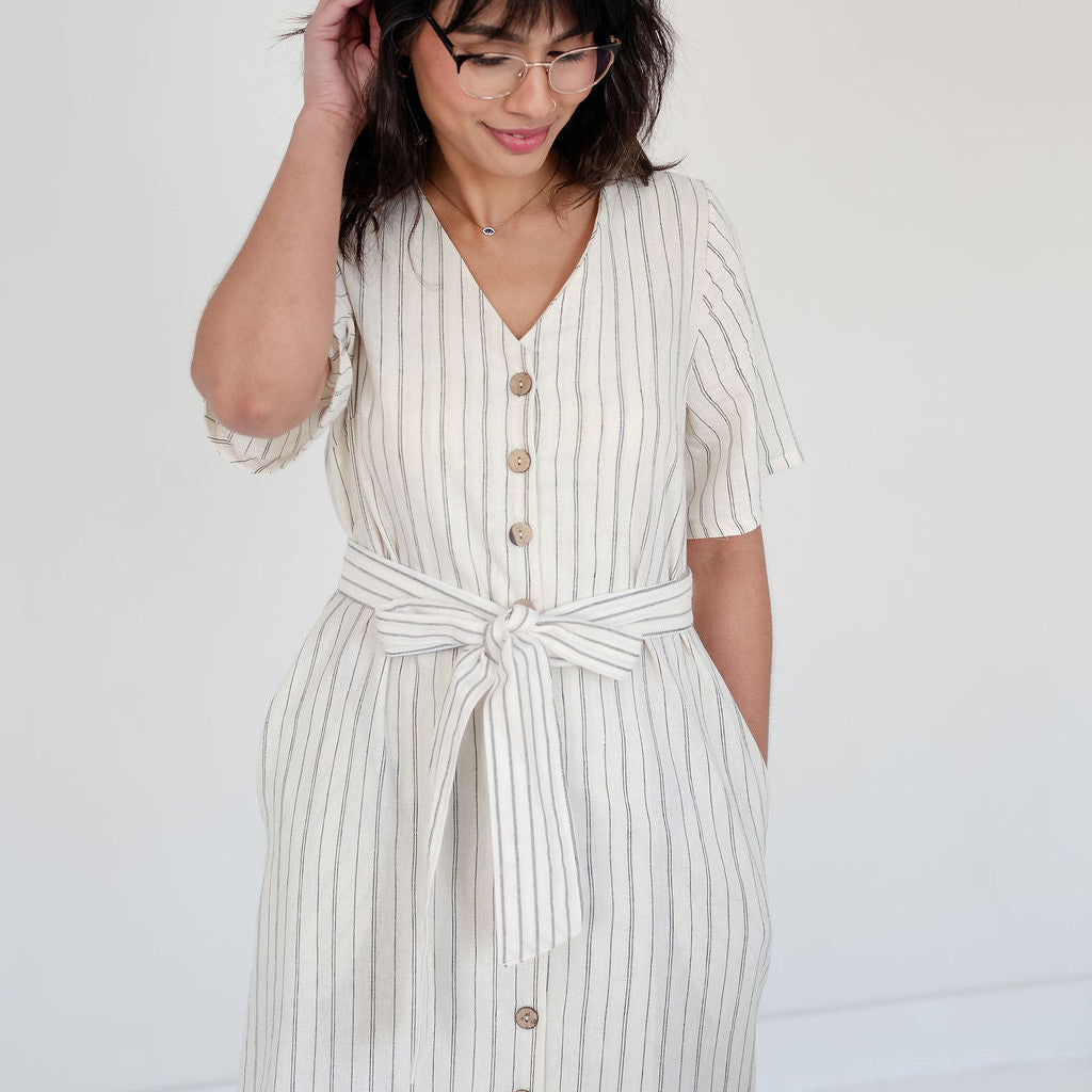Woman wearing a white and NAVY HEMP AND ORGANIC COTTON striped dress against a plain background. MADE IN ALBERTA CANADA