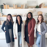 four women wearing long duster cardigan sweaters