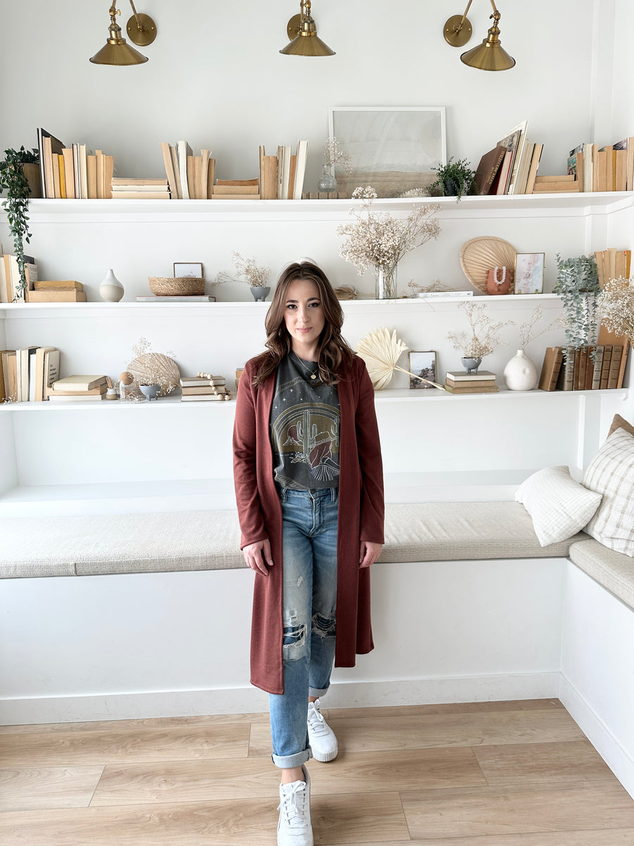 woman wearing long duster cardigan with graphic t shirt and jeans 