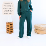 Ang Hill woman wearing dark green bamboo wide leg loungewear pants. Made in Canada