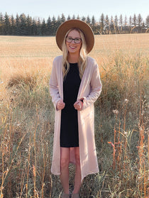 woman wearing long pink cardigan and black dress