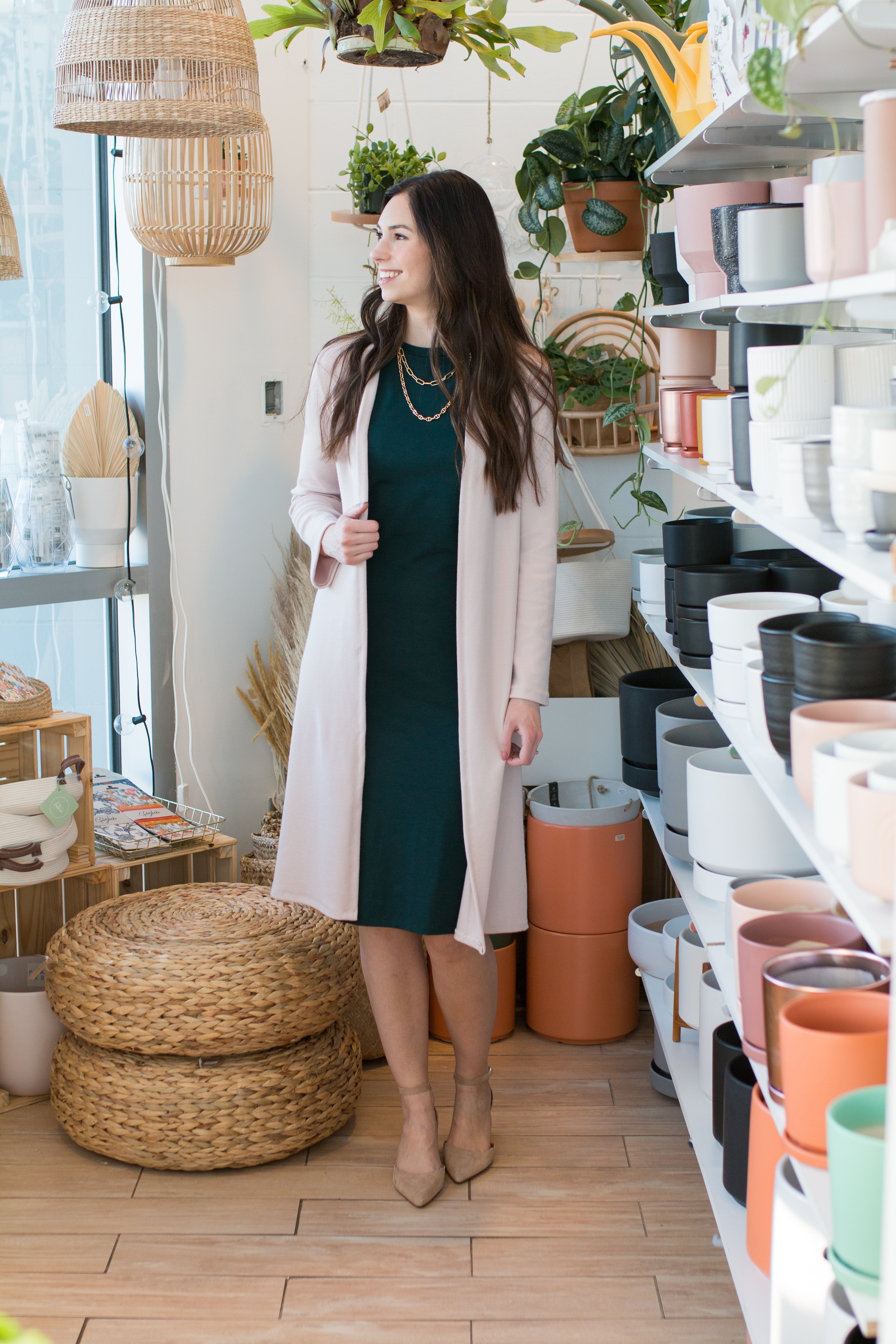 woman wearing long pink cardigan and green high neck tank dress