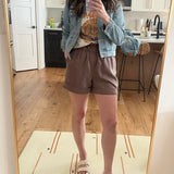 brown shorts, graphic tee and denim jacket