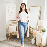woman wearing long pink cardigan and white v-neck t-shirt and jeans