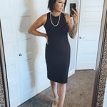 woman wearing black midi tank dress standing in mirror