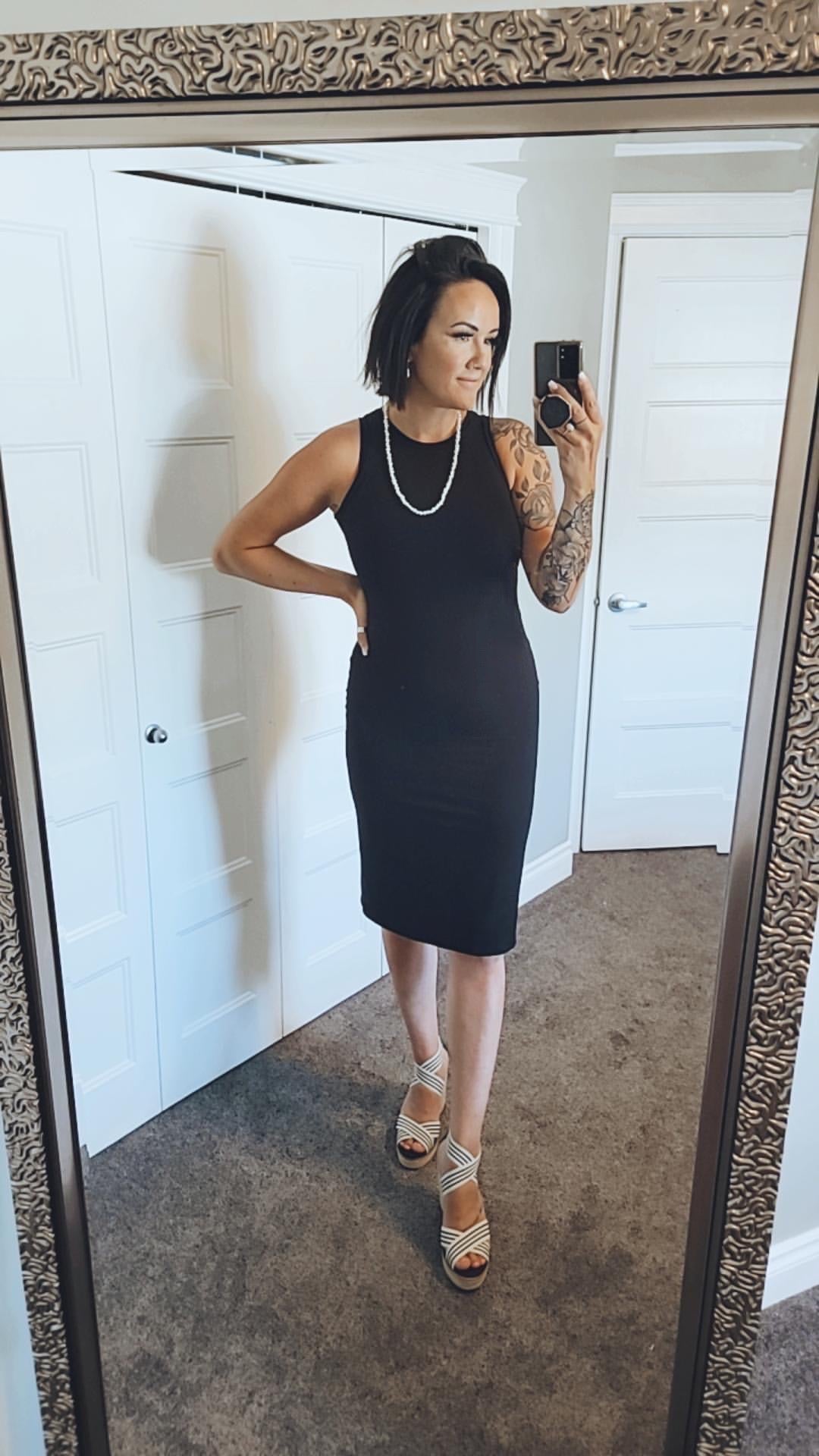 woman wearing black midi tank dress standing in mirror