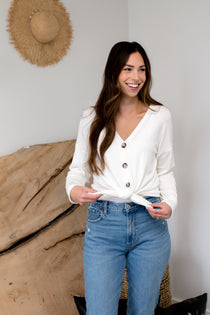model smiling with cream cardigan with buttons