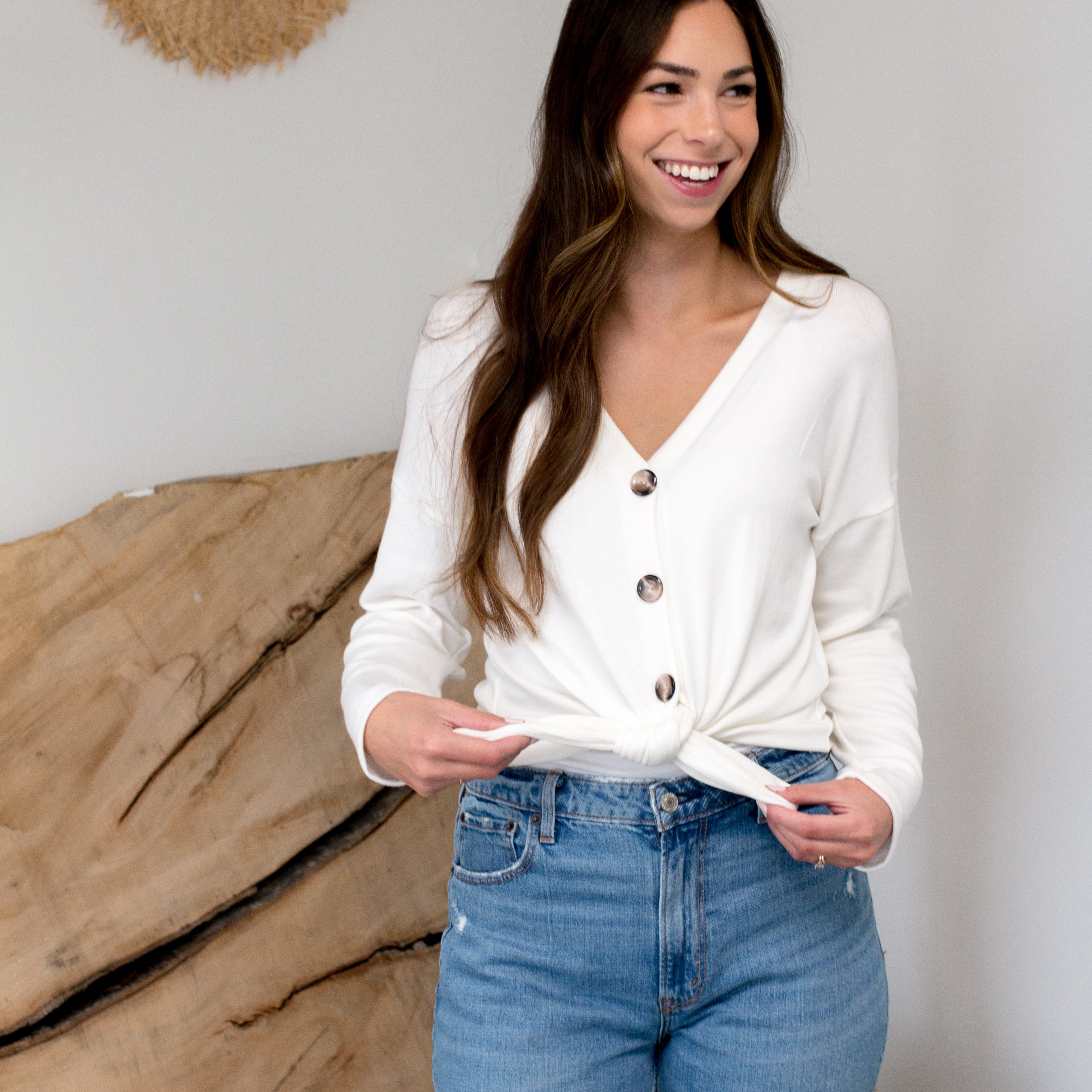 model smiling with cream cardigan with buttons