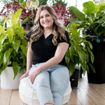 blonde woman sitting in black vneck t shirt and jeans