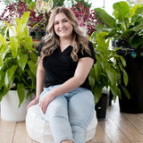 blonde woman sitting in black vneck t shirt and jeans