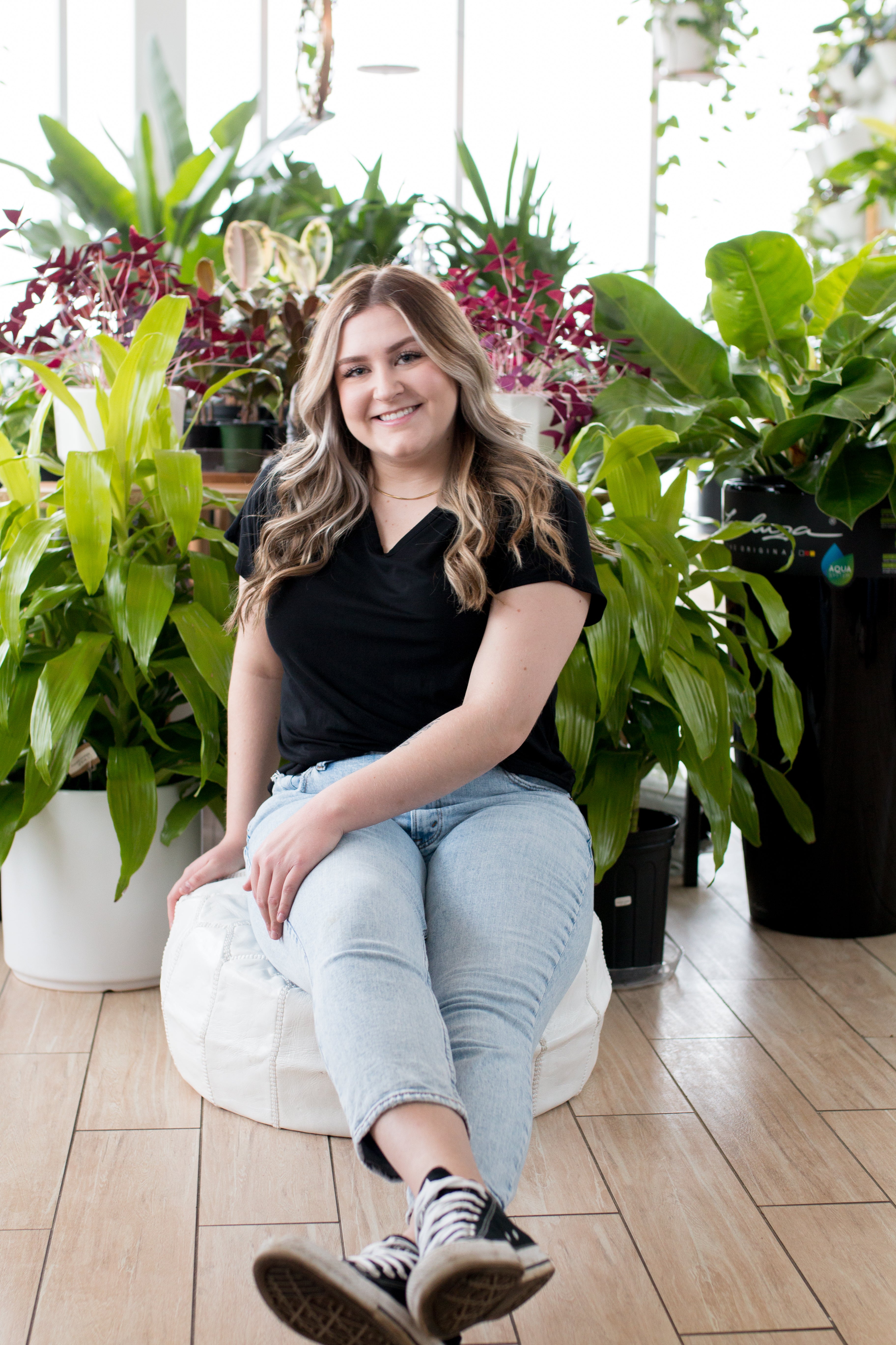 blonde woman sitting in black vneck t shirt and jeans