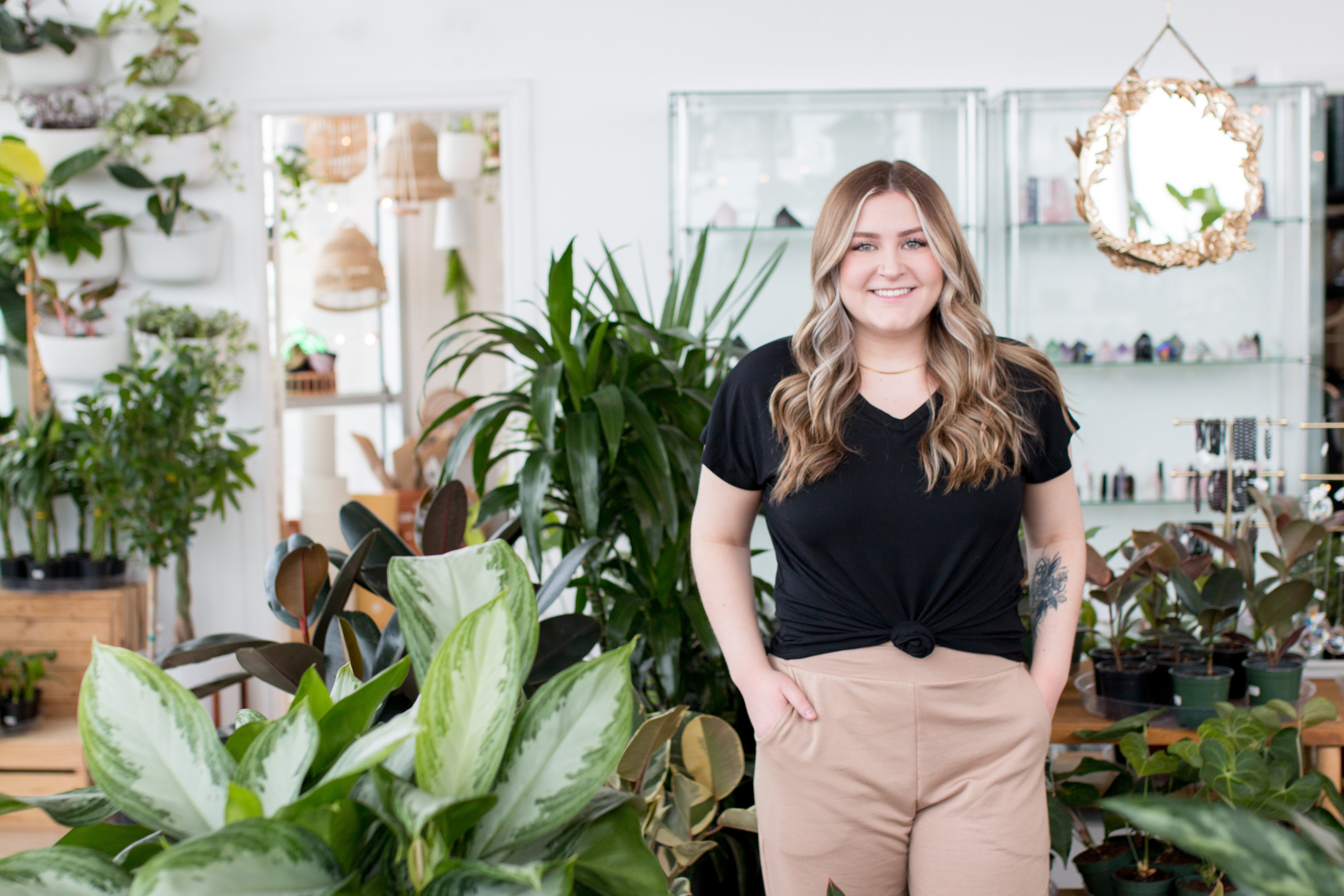 blonde woman standing in black vneck t shirt and beige joggers