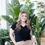 blonde woman standing in black vneck t shirt and joggers