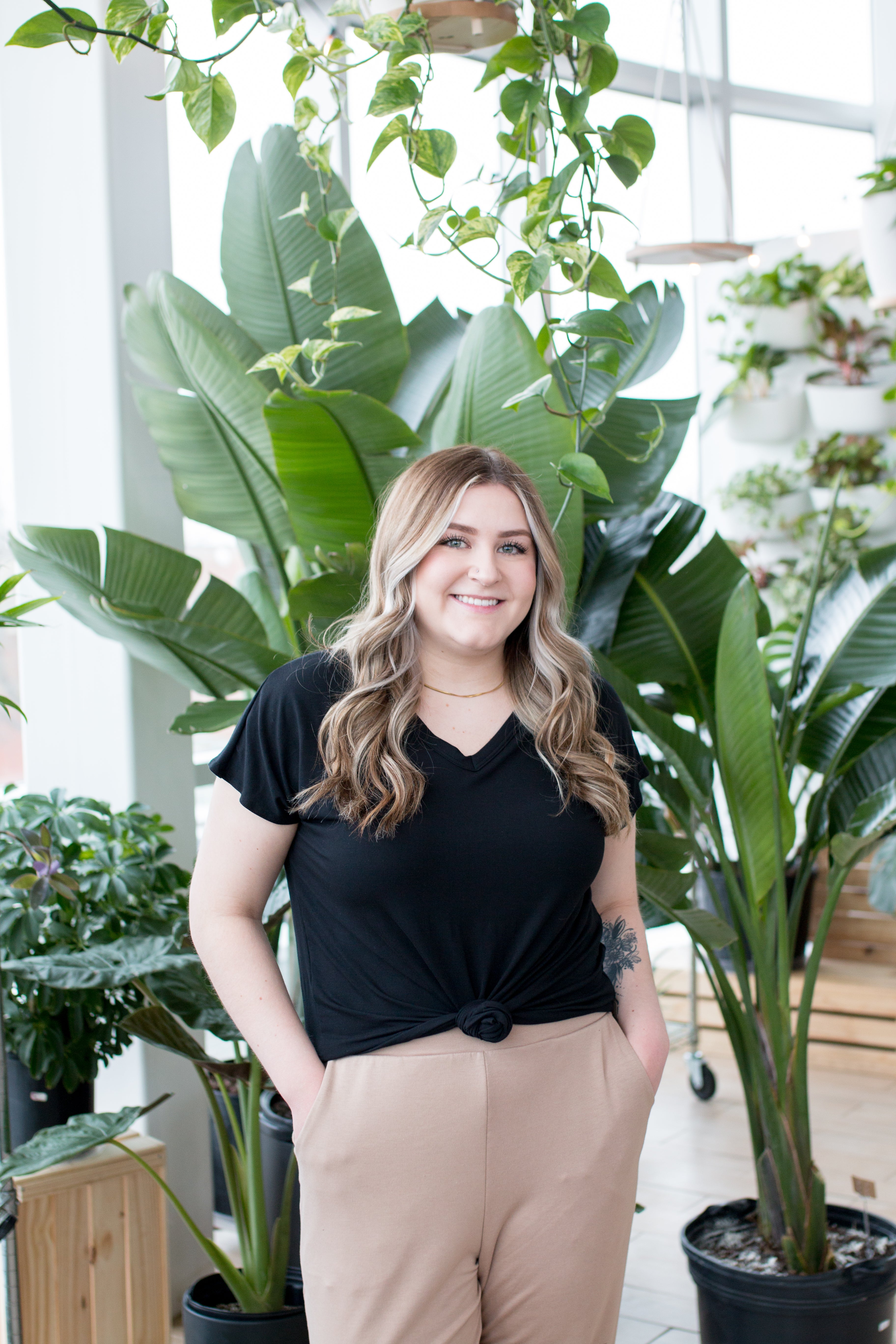 blonde woman standing in black vneck t shirt and joggers