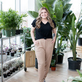 blonde woman sitting in black vneck t shirt and joggers